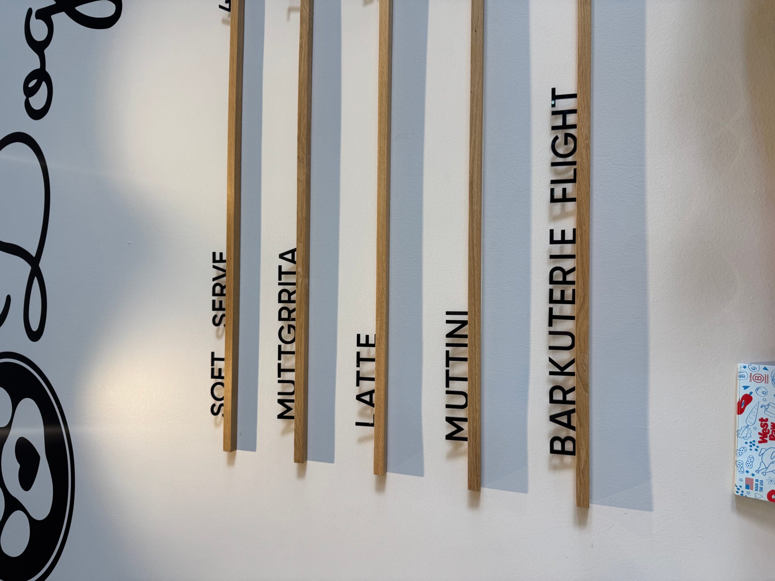 Vertical wooden strips with black text, names of people or characters, on a white background.