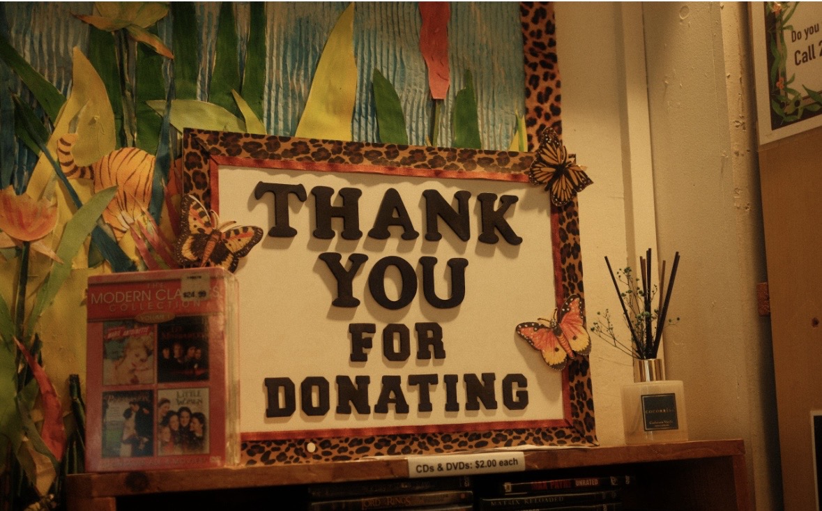 Thank you sign with a leopard print border, butterflies, and a small photo display on a shelf.
