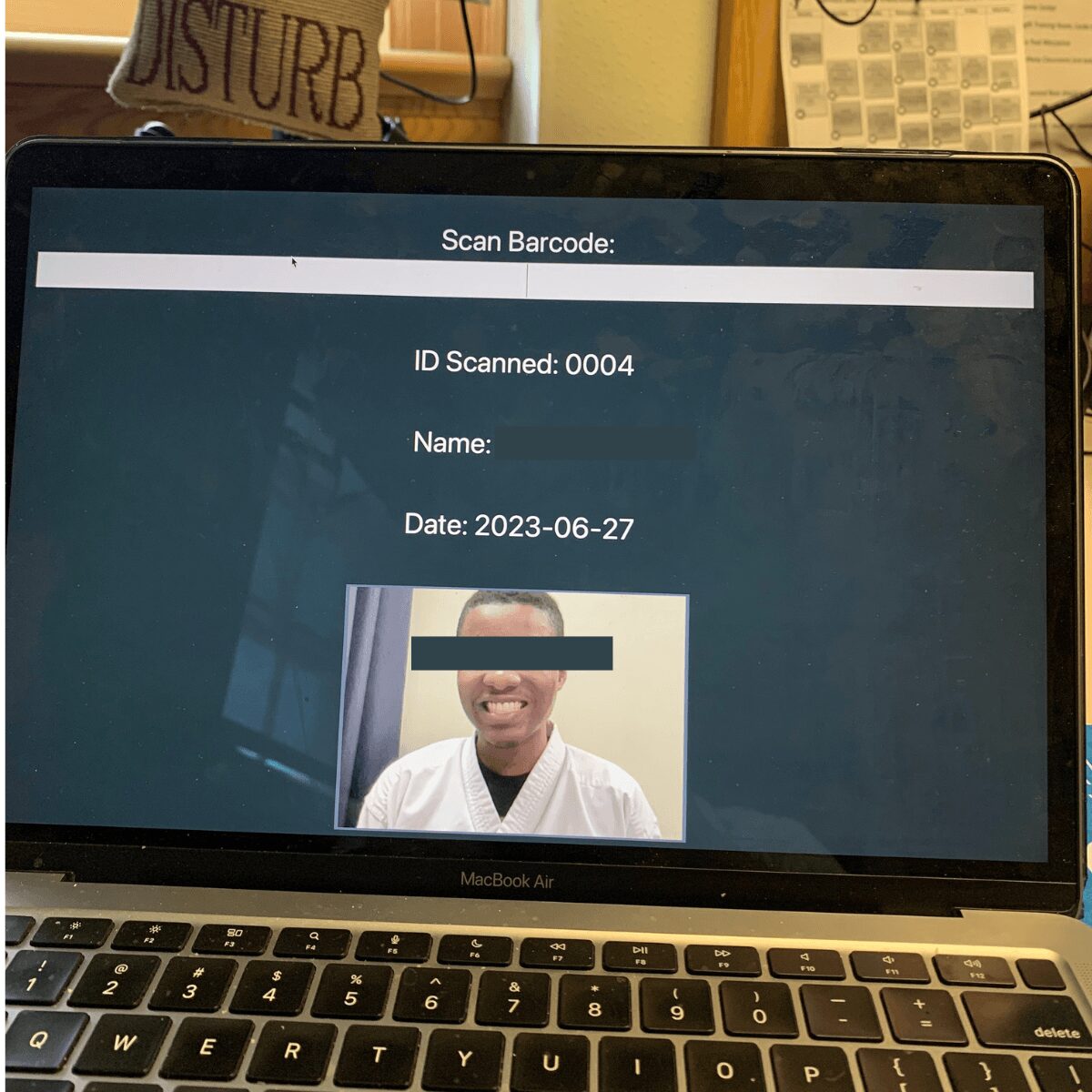 Laptop screen displaying barcode scan details and a photo of a smiling person in a white shirt.