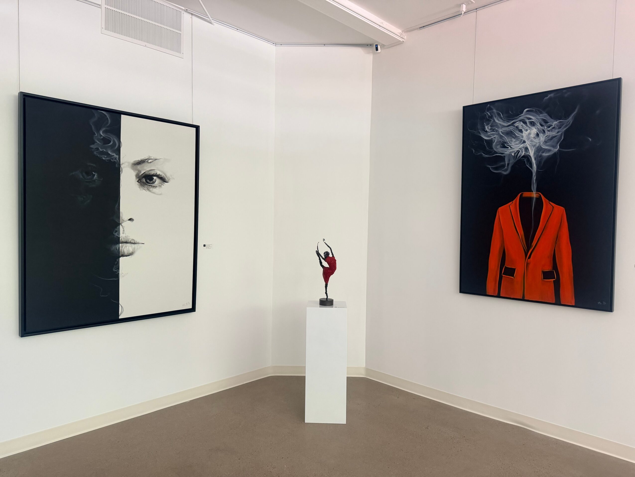 Art gallery with two paintings and a sculpture on a pedestal, white walls, and a beige floor.