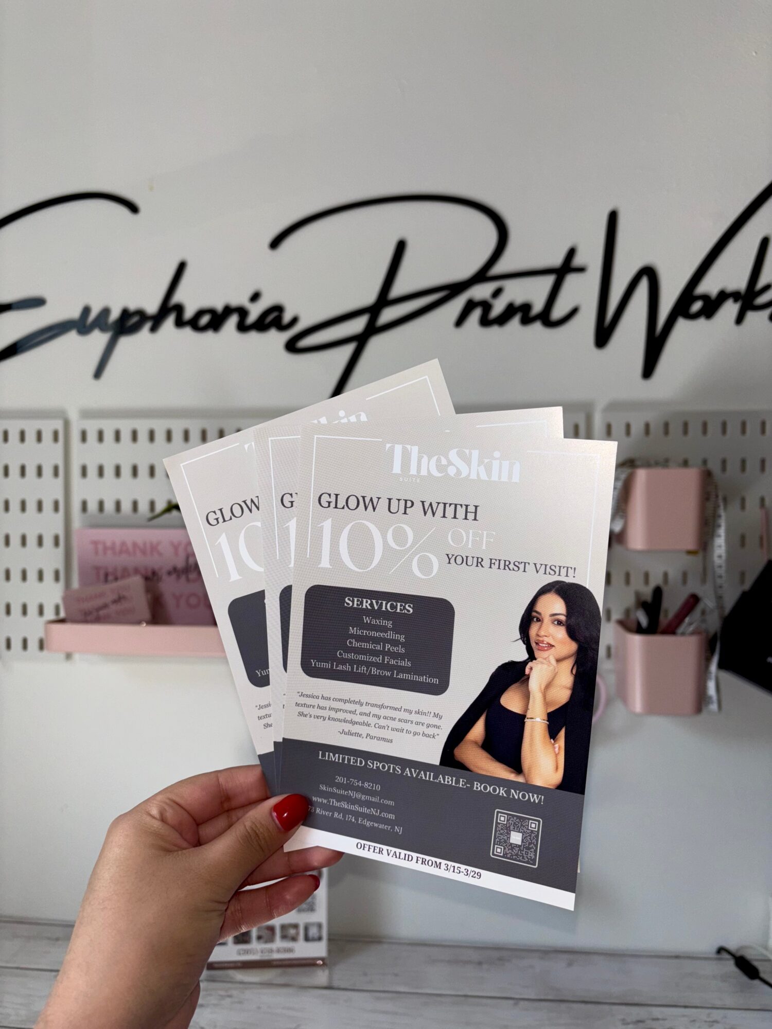 Hand holding promotional flyers for skincare with a woman and text about 10% discount.