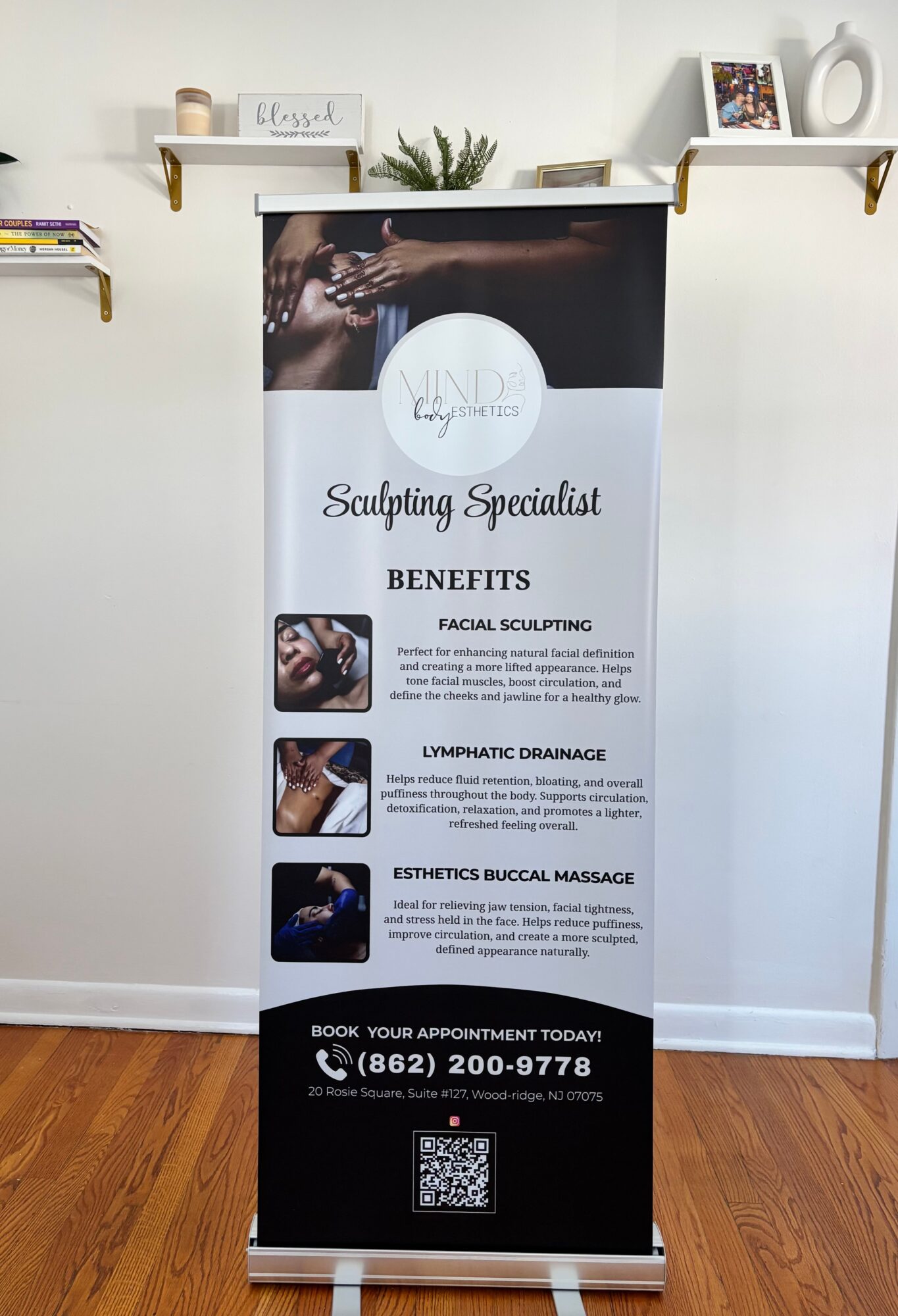 Vertical banner advertising sculpting services with benefits listed, placed in front of a white wall with shelves and decor, on a wooden floor.