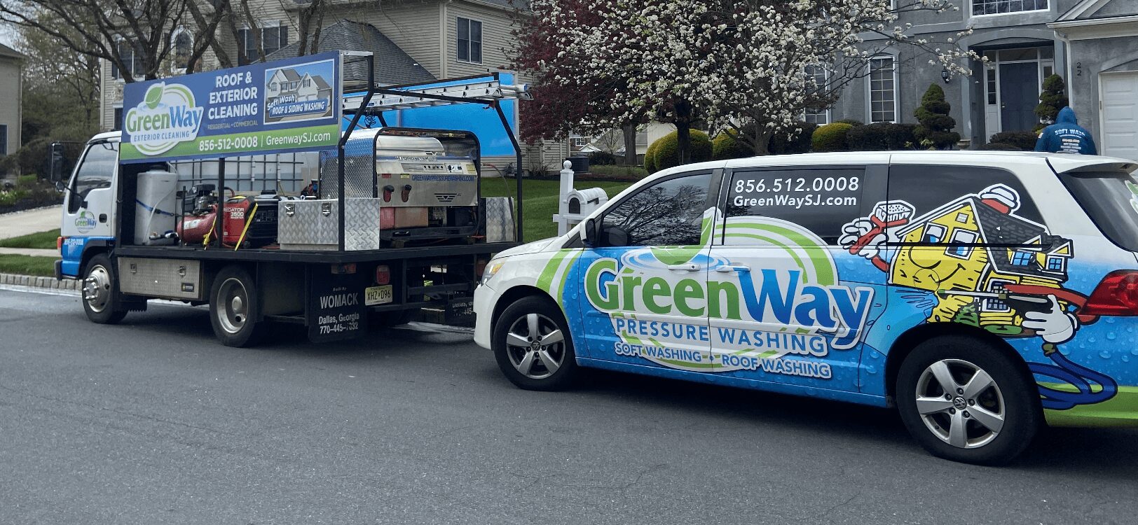 Two vehicles parked on a street, one with a company logo for GreenWay Pressure Washing, the other a service truck.