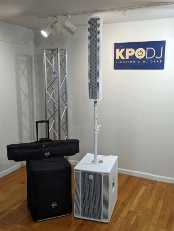 Indoor space with DJ equipment, a tall speaker, and a sign reading 'KPDJ' on the wall.
