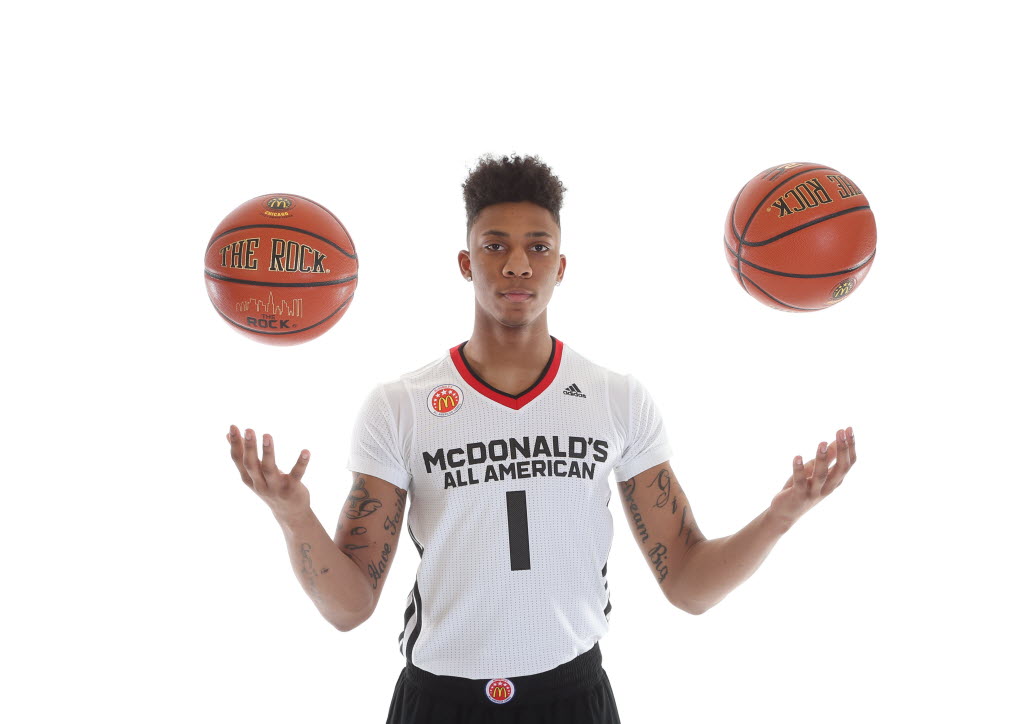 A basketball player in a white jersey with the number 1, juggling two basketballs against a white background.