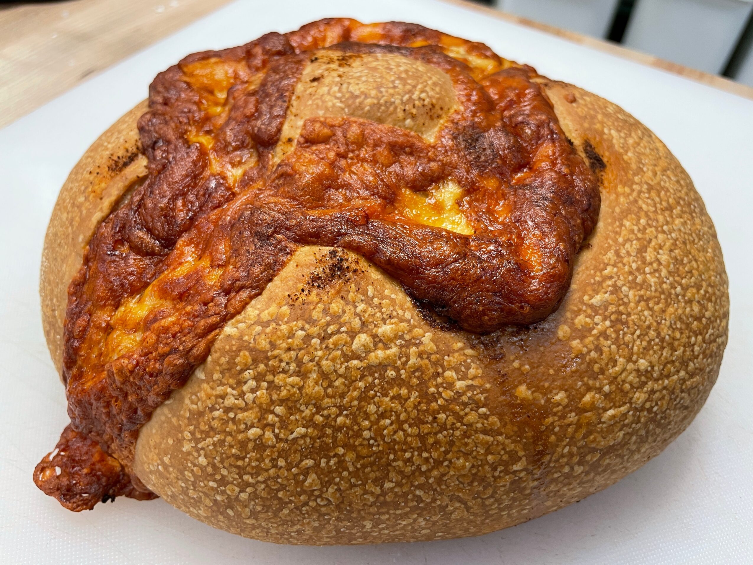Bread roll filled with a large piece of fried chicken, served on a white plate.