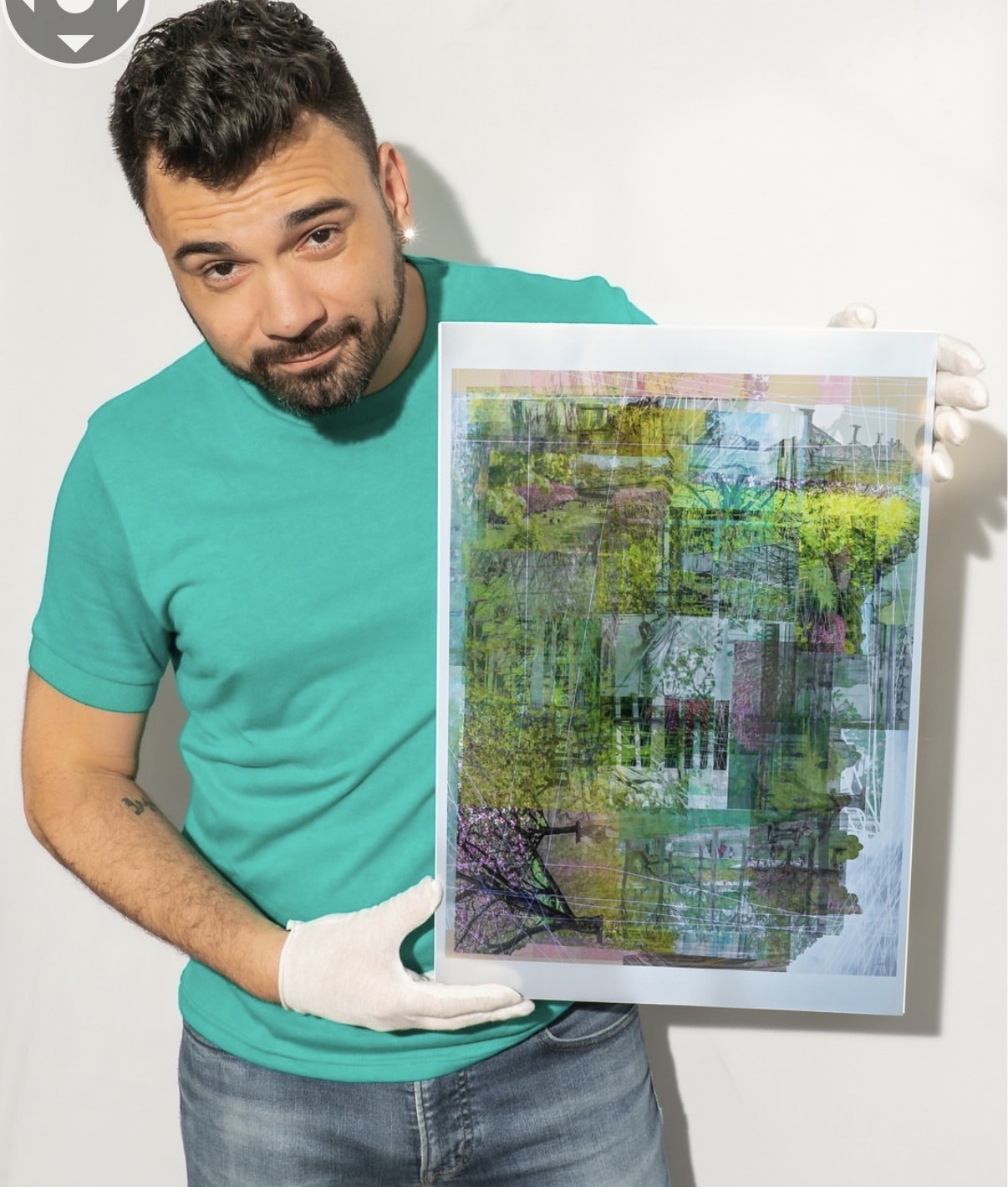 Man with dark hair and beard wearing a teal shirt and white gloves holding an abstract painting against a white background.