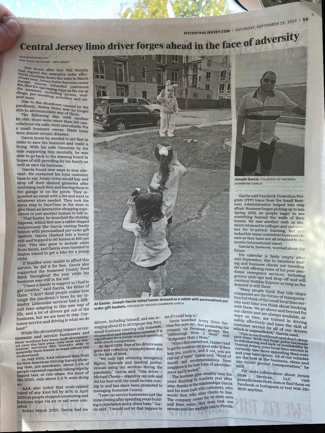Newspaper article with a photo of a girl and a dog in a park, and a man standing nearby, with text around.