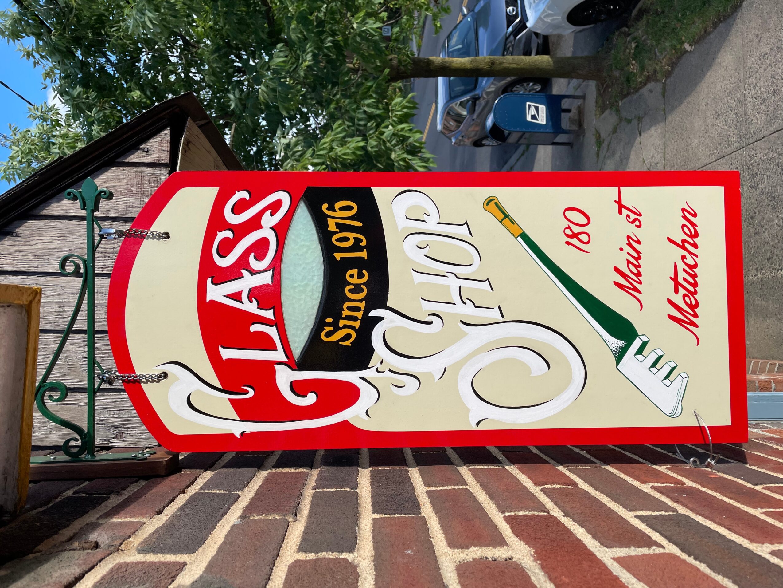 Vintage-style sign with red, white, and gold colors, advertising a classic product since 1916, with a bottle illustration and text.