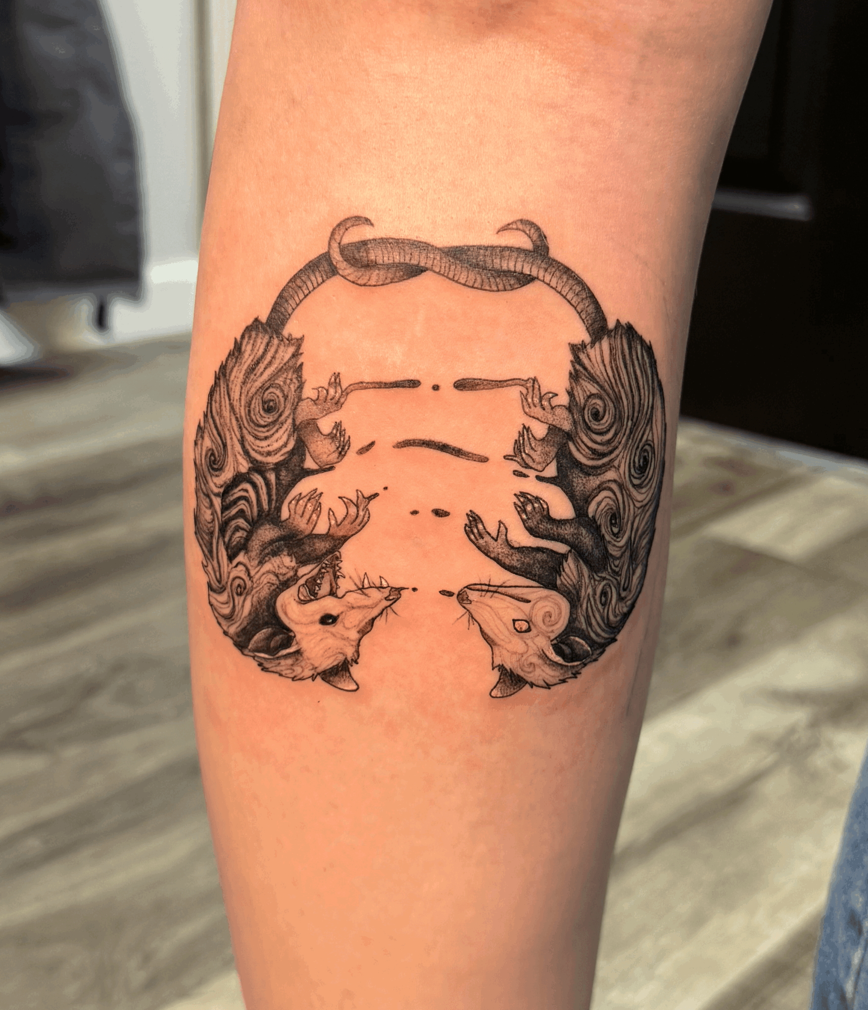 Tattoo of two symmetrical, detailed crabs facing each other with claws raised, on a person's leg.