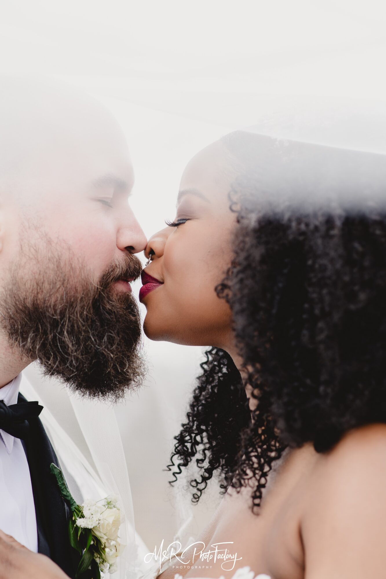 A close-up of a man and woman about to kiss, with their faces close and eyes closed.