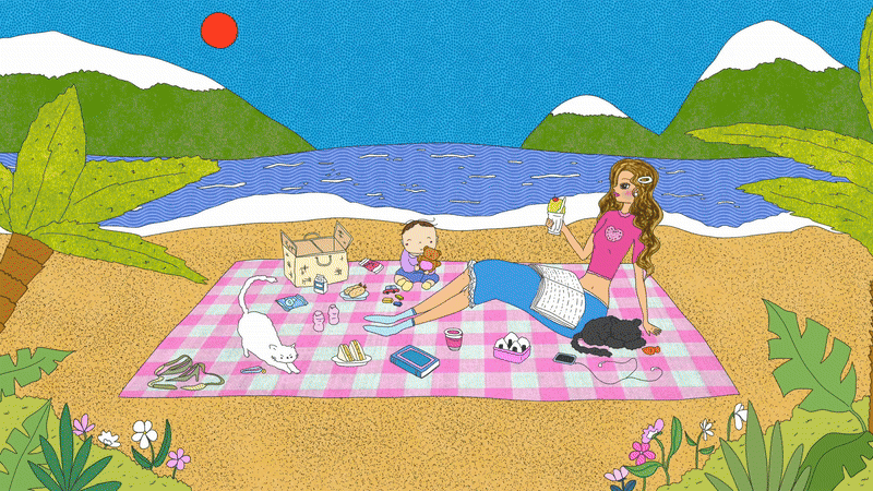 People having a picnic on a blanket near a lake with mountains and trees in the background.