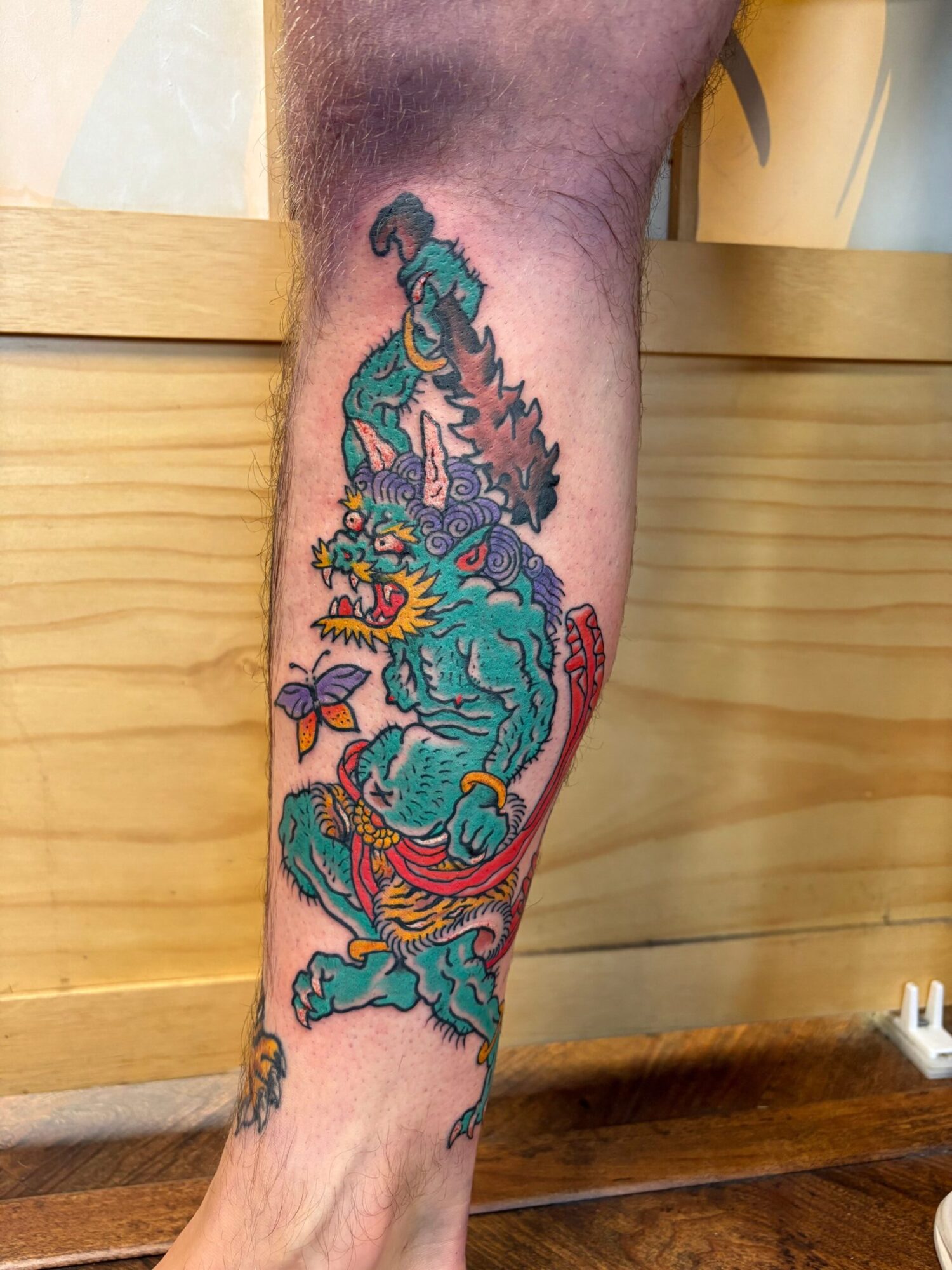 Colorful tattoo of a dragon on a person's forearm, with detailed scales and flowing design.