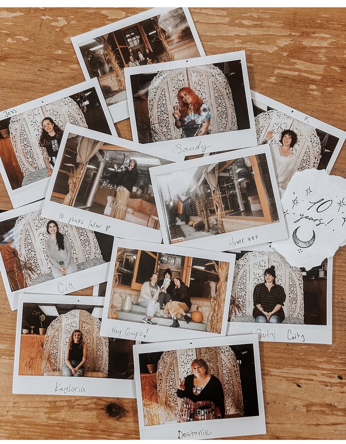 Multiple printed photographs of a woman in various settings, some with decorative backgrounds, scattered on a wooden surface.