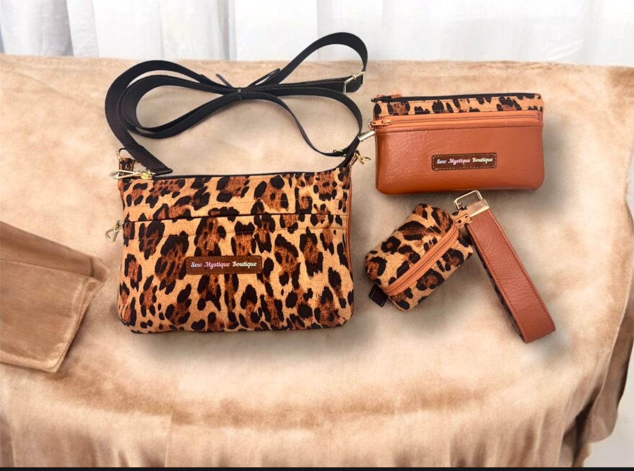 Leopard print bag, small brown wallet, leopard print keychain, and brown strap on a beige surface.