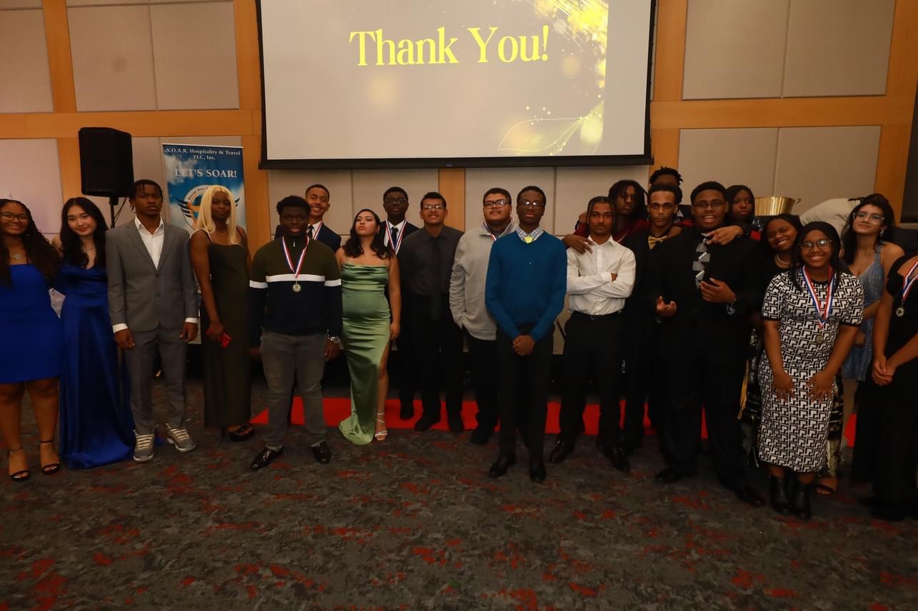 Group of people standing in front of a screen displaying 'Thank You!' in a conference room, some smiling and posing for the photo.