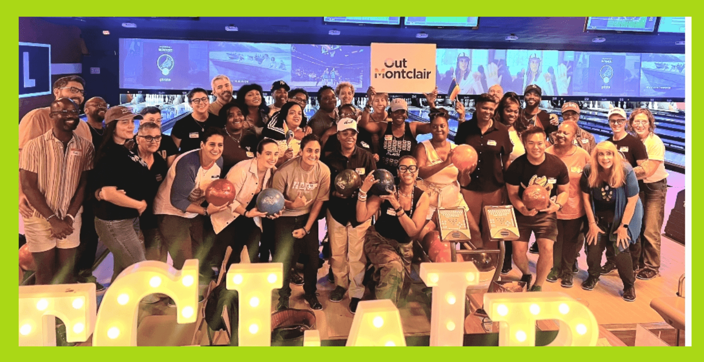 Group of people gathered indoors with large illuminated letters spelling 'ACT' in front.