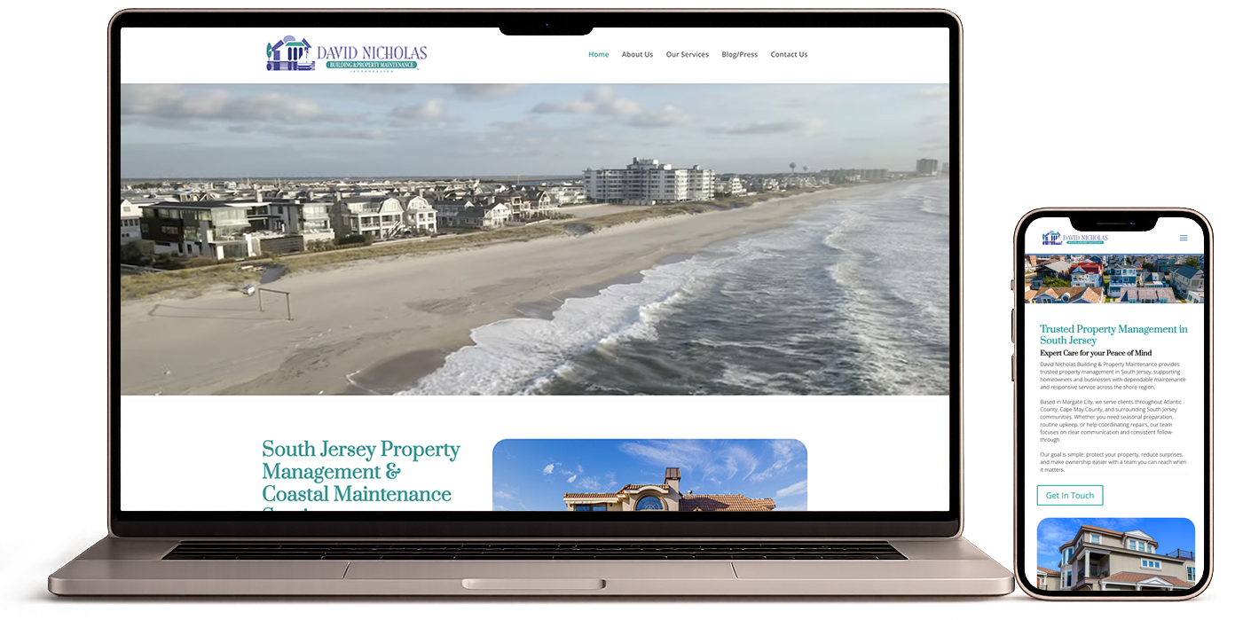 Laptop and smartphone displaying a coastal property management website with beach and buildings in background.
