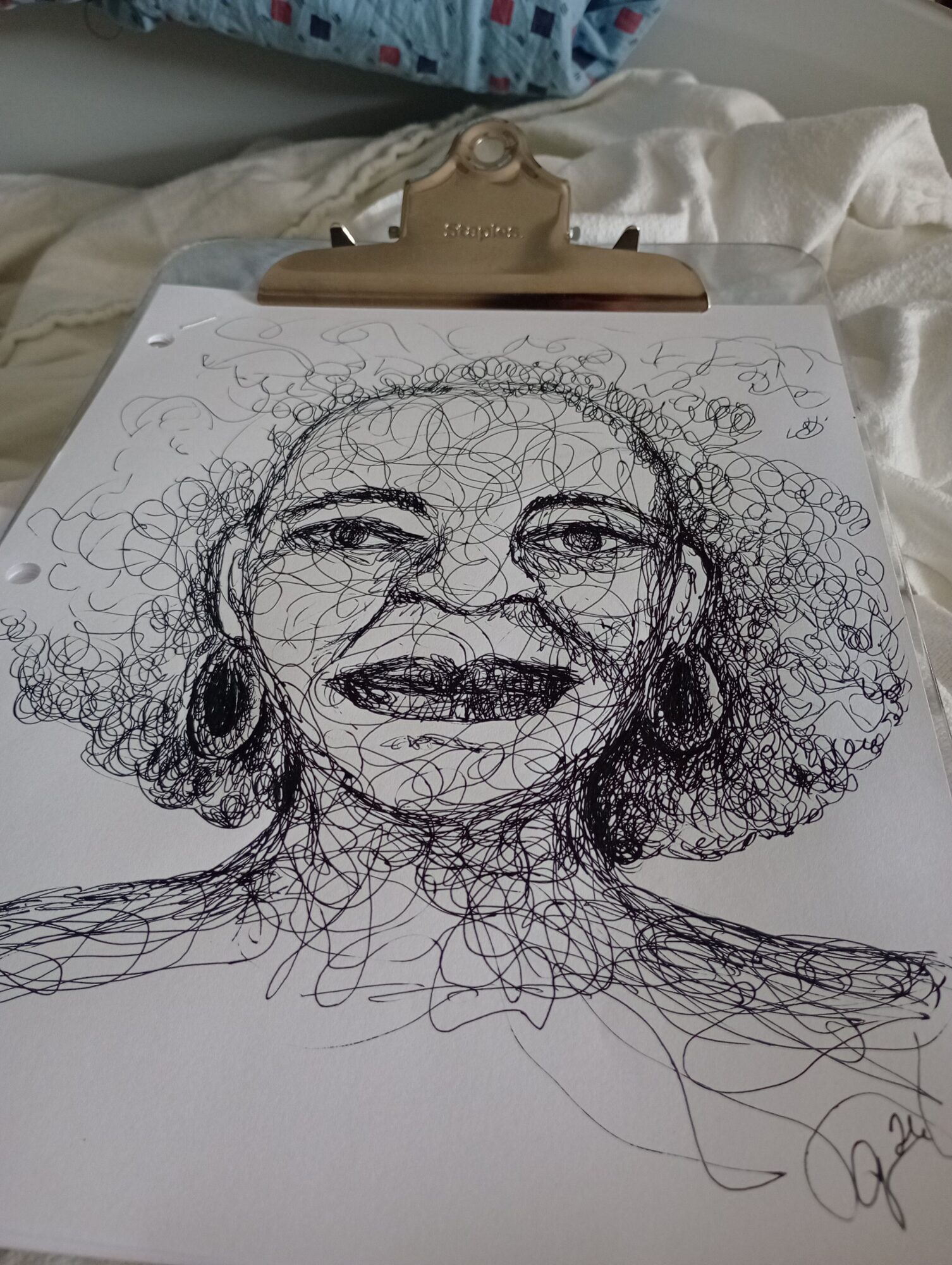 Scribbled sketch of a person's face with closed eyes and curly hair, on white paper, held by a clip.