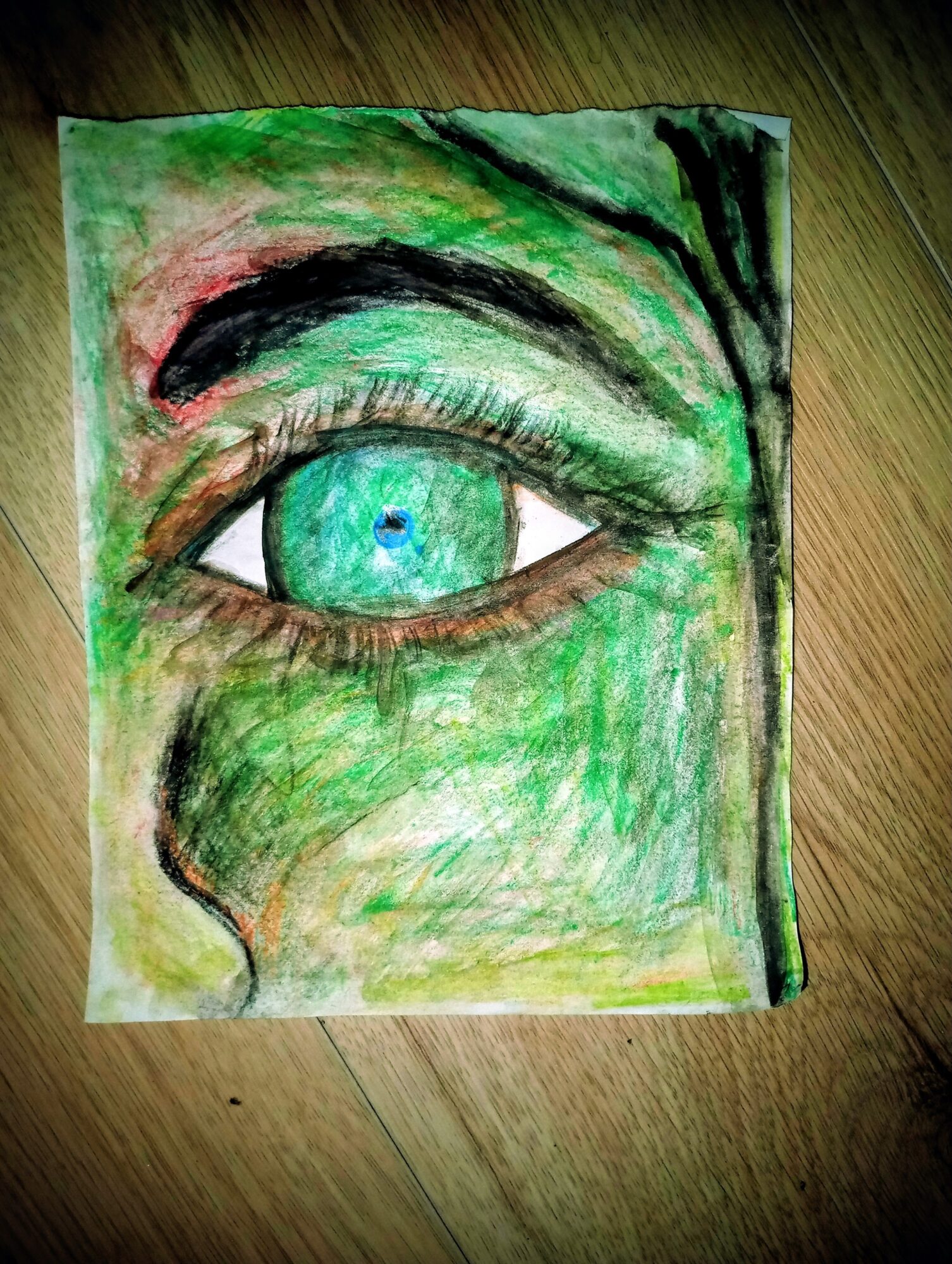 Drawing of a human eye with a green iris, surrounded by green and black shading, on a textured paper background.