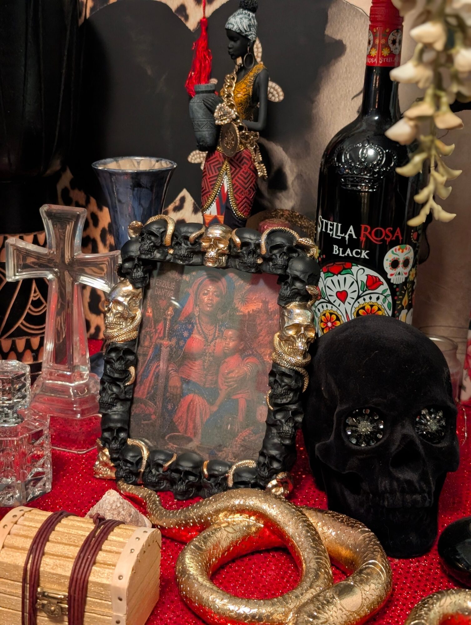 Decorative items including a skull, a bottle labeled 'Stella Rosa Black,' a mirror, and various ornaments on a table.