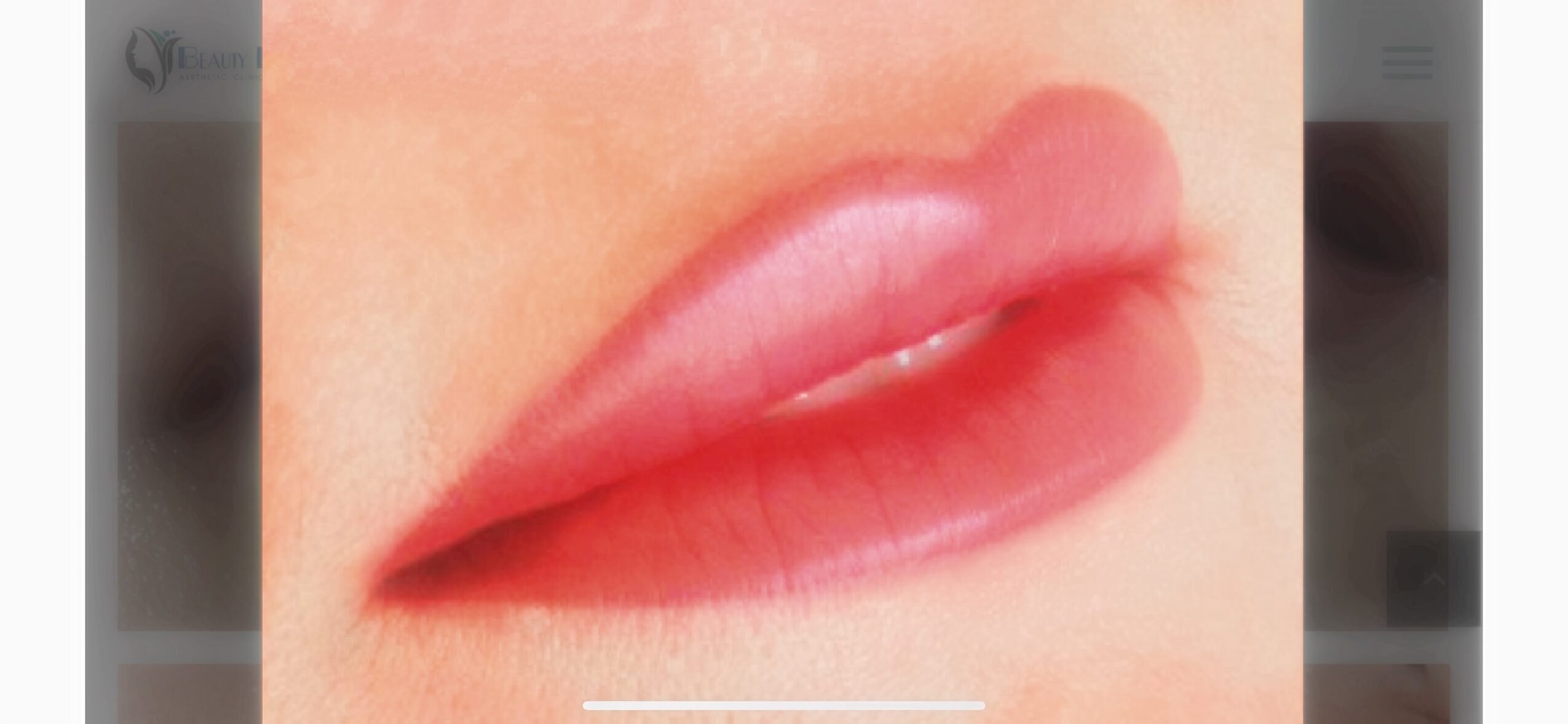 Close-up of lips with pink lipstick, slightly parted, showing teeth, with smooth skin around.