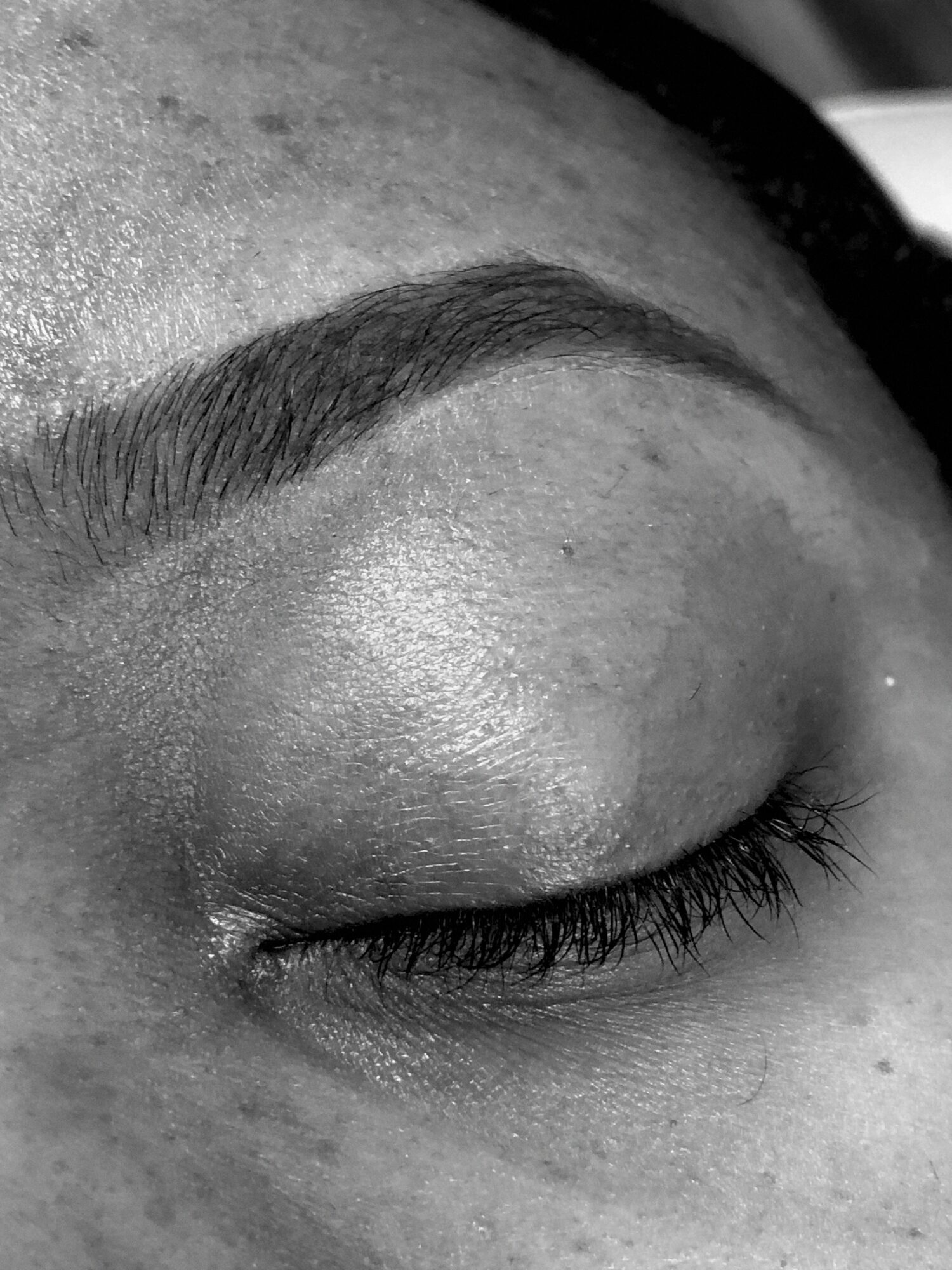 Close-up of a closed eye with well-groomed eyebrow and long eyelashes.