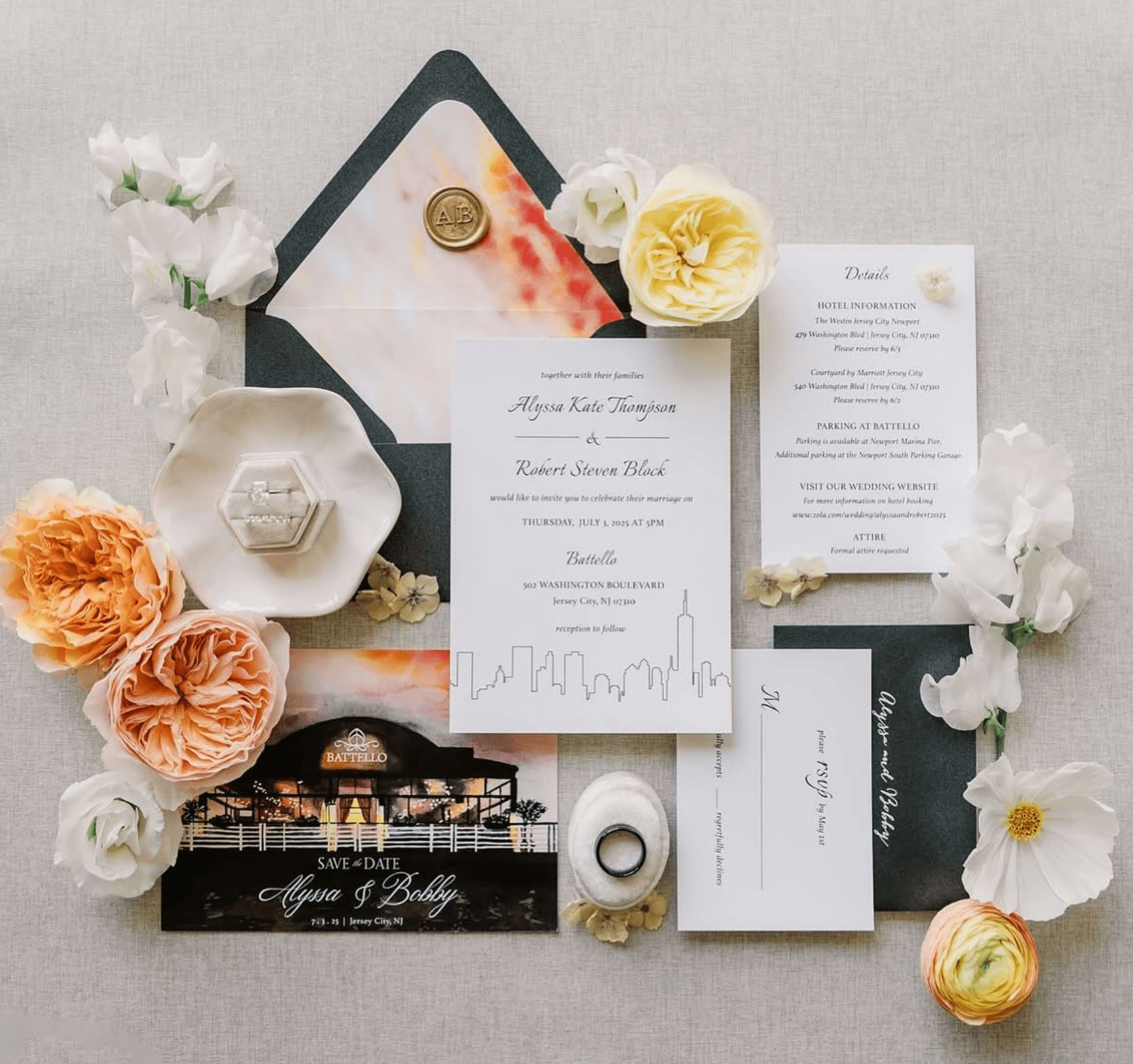 Wedding invitation suite with flowers, envelope, and decorative items arranged on a light surface.