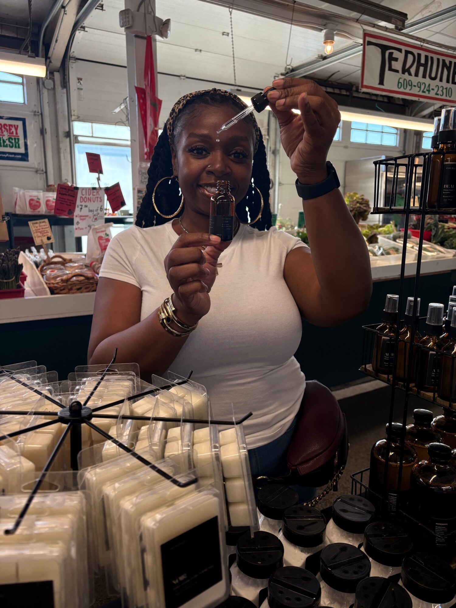 Woman taking a selfie in a store, holding a phone, with shelves and products in the background.