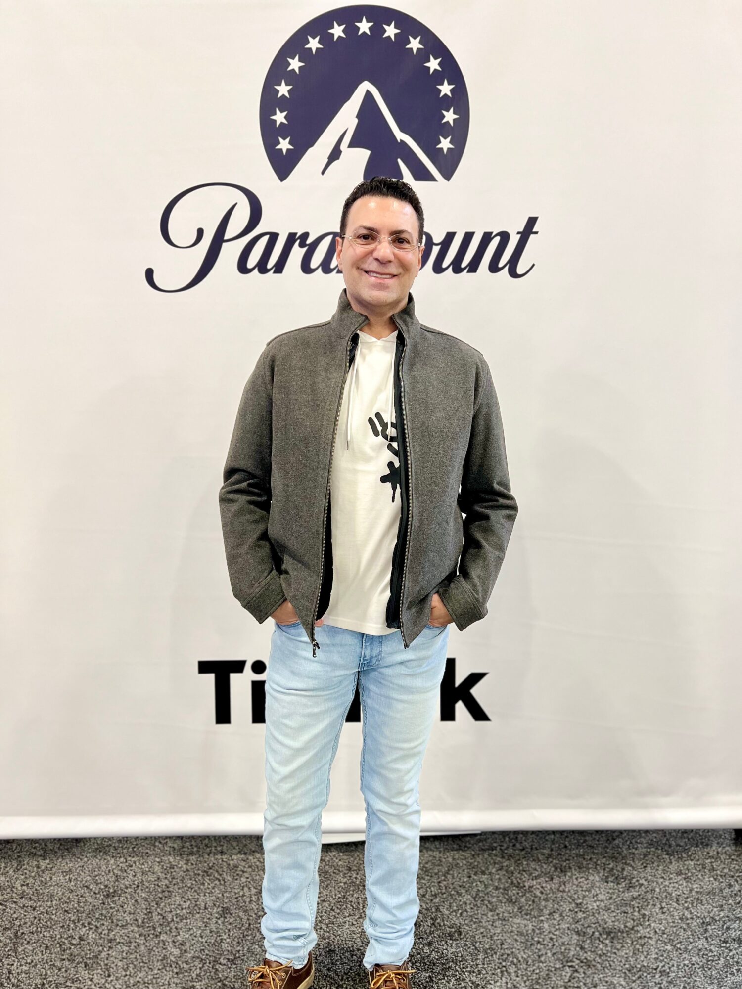 Person standing in front of a Paramount logo backdrop.